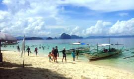 Tourist on a white sand beach in the Philippines